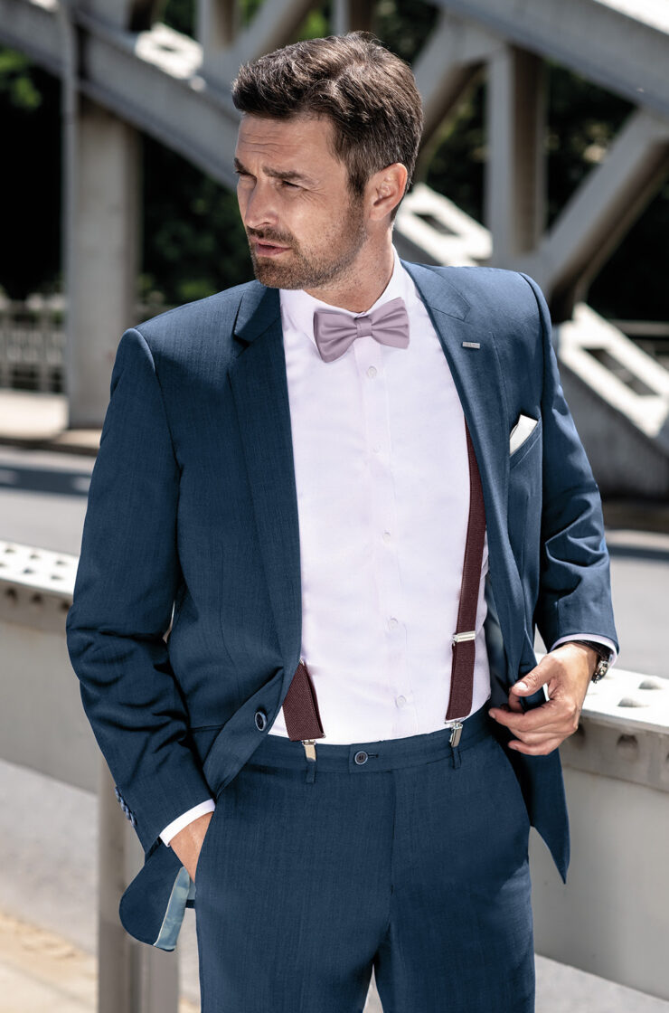 Pánský oblek BANDI Pescaro v netradiční kombinaci s košilí BELLORI Bianco, motýlkem GALLA 20 Polvere, kapešníčkem GALLA 01 oživené o stylové pánské šle EXCLUSIVE 17